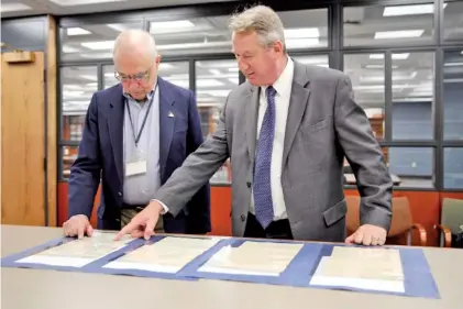  ?? AP PHOTO/MICHAEL HILL ?? Jim Folts, left, head of researcher services at the New York state archives, and State Archivist Thomas Ruller, view 1828 court documents related to Sojourner Truth at the New York State Archives in Albany N.Y., on Thursday.