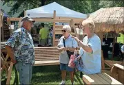  ?? John Popham / Rome News-Tribune ?? Jerry Lashley (from left) of Lithia Springs talks with potential customers Jackie Brook and Ferrell Glover about his cypress outdoor furniture at the festival on Saturday.