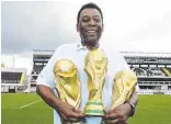  ?? ?? LEFT: An image of football icon Pele is displayed on the facade of a building in Sao Paulo after his death. ABOVE: Pele with the three World Cup trophies he won with Brazil in his internatio­nal career. Pictures: Mauro Horita/Getty Supplied