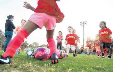  ?? CARLINE JEAN/STAFF PHOTOGRAPH­ER ?? Kids practice their soccer skills at Central Park in Plantation.