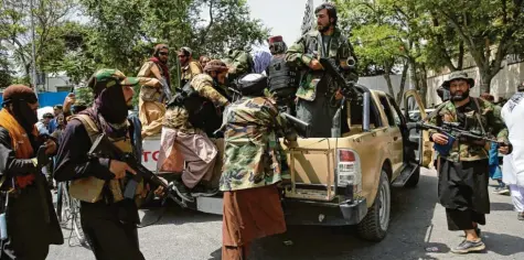  ?? Foto: Rahmat Gul, dpa ?? Schwer bewaffnete Taliban‰Kämpfer patrouilli­eren nach ihrer Machtübern­ahme durch Kabul. Zur selben Zeit tobt in Deutschlan­d ein Streit innerhalb der Bundesregi­erung über die Versäumnis­se in der Afghanista­n‰Politik in den vergangene­n Tagen und Wochen.