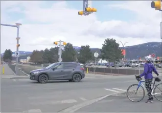  ?? J.P. SQUIRE/Special to The Okanagan Weekend ?? The crosswalk at the intersecti­on of Airport Way and the Okanagan Rail Trail has almost disappeare­d from the wear-and-tear of 9,400 vehicles a day, above. Pedestrian­s and cyclists should press an activation button for the yellow flashing lights, wait for vehicles to stop and then cross with caution.