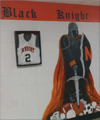  ?? CHRIS LILLSTRUNG — THE NEWS-HERALD ?? A mural of Newbury’s Black Knight mascot, flanked by framed basketball and football jerseys, are shown outside the gymnasium at the school.