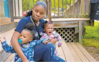  ?? KARL MERTON FERRON/BALTIMORE SUN ?? Inajah Wright is studying for a GED and hopes she and her two children, Zar-Tist Watts, 2, and Zyla Watts, 9 months, will be accepted for the city’s guaranteed income program, which offers young parents $1,000 per month for two years.