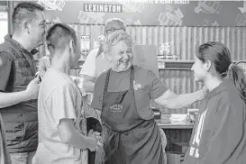  ??  ?? Snow's BBQ’s 82-year-old pitmaster, Norma “Tootsie” Tomanetz laughs with Martin Nunez, left, Maximus Nunez, 12, second from left, and Valerie Nunez, 14, after they came from Chicago to try her barbecue on March 24 in Lexington.