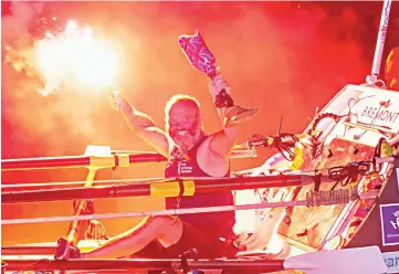  ??  ?? Spencer holds a red flare and his prosthesis as he arrives in Cayenne, French Guiana, after smashing solo Atlantic rowing record from mainland Europe to South America. — AFP photo