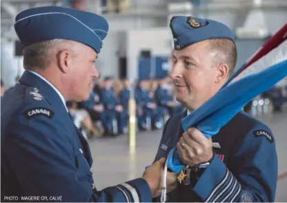  ?? PHOTO : IMAGERIE CPL CALVÉ ?? Le colonel Guillette reçoit le drapeau des mains du major- général Christian Drouin, commandant de la 1 DAC, afin de signifier sa prise de commandeme­nt de la 2e Escadre.