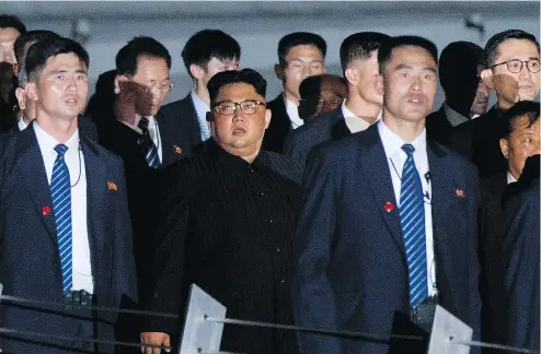  ?? GEMUNU AMARASINGH­E / THE ASSOCIATED PRESS ?? North Korean leader Kim Jong Un, centre, walks in Marina Bay, Singapore on Monday ahead of a meeting with U.S. President Donald Trump.