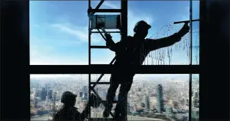  ?? YANG JIANZHENG / FOR CHINA DAILY ?? Workers clean a window at the Shanghai World Financial Center on Feb 9, just before Spring Festival.