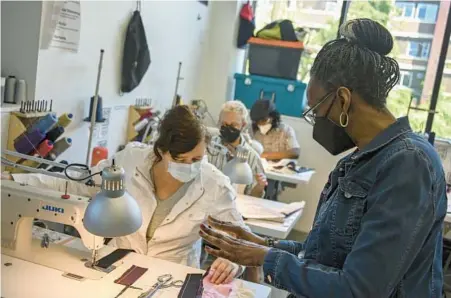  ?? KEVIN RICHARDSON/BALTIMORE SUN PHOTOS ?? Seamstress instructor Sharmane Herron, right, provides advice to a student during a class at Open Works.