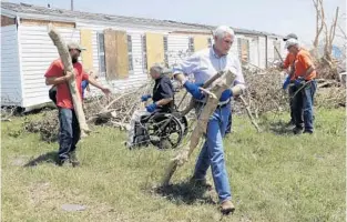  ?? ERIC GAY/ASSOCIATED PRESS Story and more Hurricane Harvey coverage, A8 ?? Vice President Mike Pence, front, and Texas Gov. Greg Abbott, center in dark shirt, help move debris Thursday in devastated Rockport, Texas.