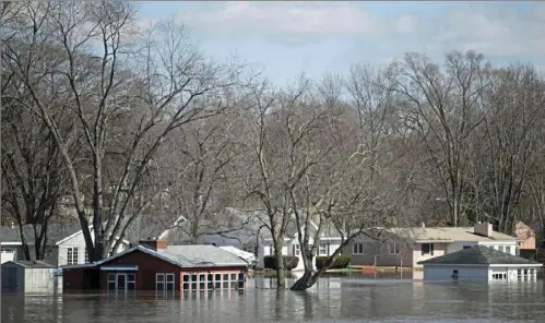  ?? Scott P. Yates/Rockford Register Star via AP ?? The Rock River crests its banks and floods Shore Drive on Saturday in Machesney Park, are at record levels after days of snow and rain. Ill. Many rivers and creeks in the Midwest