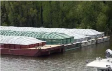  ?? AP ?? HELD UP: Barges loaded with soy beans, potash or scrap steel on the Mississipp­i River are delayed Tuesday in St. Paul, Minn., because of spring flooding.