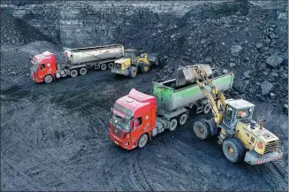  ?? WANG ZHENG / FOR CHINA DAILY ?? Trucks are loaded with coal at a coal mine in the Inner Mongolia autonomous region on Tuesday.