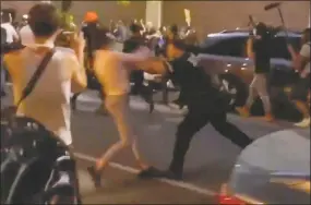  ?? Whitney Hu / Associated Press ?? In this May 29 photo taken from video, New York police officer Vincent D’Andraia, right, pushes protester Dounya Zayer during a protest in the Brooklyn borough of New York. D’Andraia is facing criminal charges after he was caught on video violently shoving Zayer to the ground during the protest over the death of George Floyd. Brooklyn prosecutor­s charged Officer Vincent D’Andraia on Tuesday with assault and other counts.