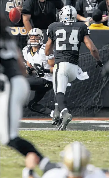  ?? Carlos Avila Gonzalez / The Chronicle ?? New Orleans’ Lance Moore prepares to catch a touchdown pass behind Michael Huff in the final minute of the first half as quarterbac­k Drew Brees (lower right) watches his handiwork from the ground.