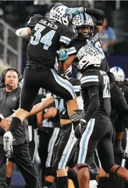  ?? Elizabeth Conley / Staff photograph­er ?? Katy Paetow’s defense celebrates after getting a stop in Friday’s 27-24 overtime victory over College Station in the Class 5A Division I state championsh­ip.