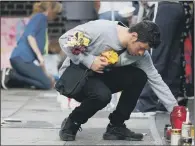  ??  ?? A man places flowers at the memorial.