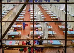  ?? — PTI ?? Medics distribute packaged food among Covid patients inside an isolation ward at Shehnai Banquet Hall in New Delhi on Thursday.