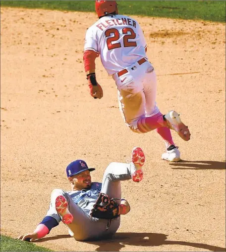  ?? Photograph­s by Wally Skalij Los Angeles Times ?? THE ANGELS’ David Fletcher runs to third after he stole second and the throw got past Dodgers infielder Gavin Lux in the eighth inning.