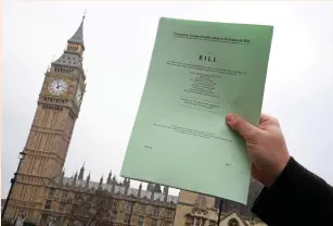  ?? (Toby Melville/Reuters) ?? A JOURNALIST poses with a copy of the Brexit Article 50 bill, introduced by the government to seek parliament­ary approval to start the process of leaving the European Union, in front of the Houses of Parliament in London, January 26, 2017.