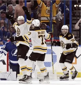  ?? Ap pHotos ?? SOLID TWO POINTS: Charlie Coyle (13) celebrates his game-winning goal in overtime with Charlie McAvoy and Jake DeBrusk (74) on Friday night in Tampa. Below, Linus Ullmark denies Tampa Bay’s Ondrej Palat during overtime.