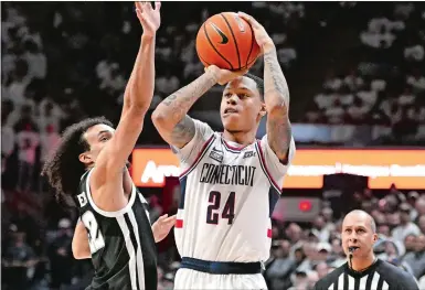  ?? JESSICA HILL/AP PHOTO ?? UConn’s Jordan Hawkins (24) shoots as Providence’s Devin Carter (22) defends during the second half of Wednesday’s game at Gampel Pavilion in Storrs.