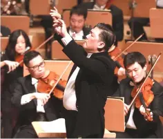  ??  ?? Long Yu conducting the Shanghai Symphony Orchestra on a Bartok symphony.