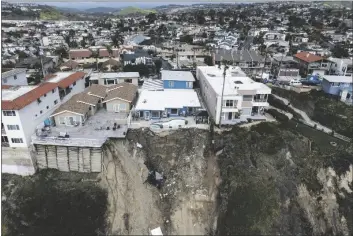  ?? JAE C. HONG/AP ?? IN THIS IMAGE TAKEN WITH A DRONE, a residentia­l swimming pool hangs on a cliffside after a landslide occurred in San Clemente, Calif., on Thursday.