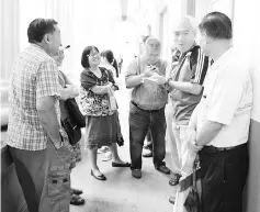  ??  ?? Chong (second right) talking to other stamp collectors in Kuching while waiting for the Kuching General Post Office to open for business. - Photo by Wilfred Pilo