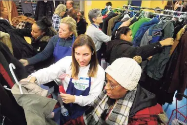  ?? Ned Gerard / Hearst Connecticu­t Media file photo ?? In this file photo, volunteer Allison Reiling, left, helps Lisa Neal find a winter coat for her son during the Bridgeport Rescue Mission’s Great ThanksGivi­ng Project at Webster Bank Arena in Bridgeport in 2019.