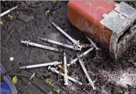  ?? CHARLES KRUPA / AP ?? Discarded used hypodermic needles without protective sheaths cover the ground last year at an encampment where opioid addicts shoot up in Lowell, Mass. The opioid crisis is killing more than 115 people every day in the United States.