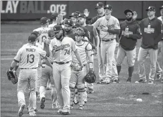  ?? AP PHOTO ?? Los Angeles Dodgers players celebrate after Game 2 of the National League Championsh­ip Series baseball game against the Milwaukee Brewers Saturday, Oct. 13, 2018, in Milwaukee.