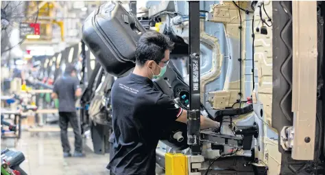  ??  ?? Men work on BMW’s plug-in hybrid assembly line in Rayong province. A newly formed consortium called ETA will make electric vehicles in Samut Prakan.