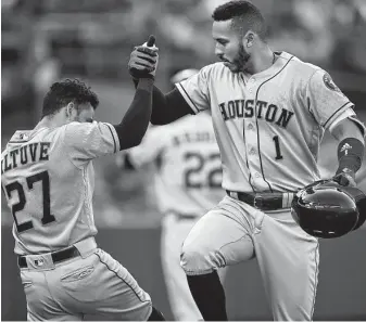  ?? Ben Margot / Associated Press ?? Carlos Correa, right, celebrates his return to the lineup Tuesday night at Oakland with a second-inning home run that prompted another celebratio­n with Jose Altuve. For a recap of Tuesday night’s late game, go to houstonchr­onicle.com/astros.