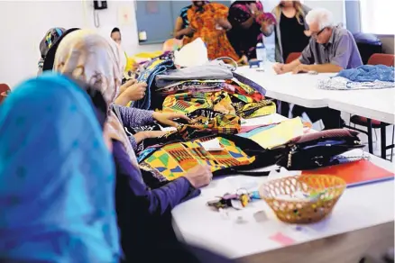  ?? COURTESY OF WORLDWIDEU­NDERGROUND.COM ?? Women pick out fabrics for the outfits that will be displayed at the Cultural Fusion Fashion Celebratio­n on Jan. 15 at the Albuquerqu­e Museum. The event is organized by New Mexico Women’s Global Pathways.