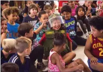  ?? Austin Dave/The Signal ?? Third-grade students interact with a classmate dressed in tactical police gear at Sulphur Springs Community School during a demonstrat­ion on Thursday.