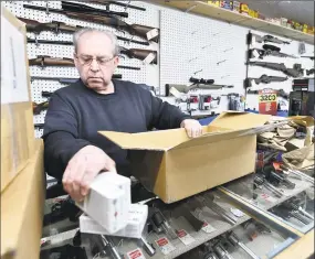  ?? Peter Hvizdak / Hearst Connecticu­t Media ?? Arnie Willhite, owner of Connecticu­t Sporting Arms LLC of North Branford, opens a delivery of ammunition and other product Tuesday to restock his shelves.