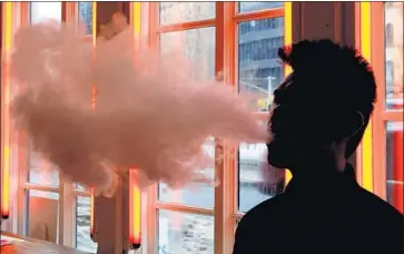  ?? Frank Franklin II Associated Press ?? BIG TOBACCO companies have more experience dealing with regulators and can more easily afford to temporaril­y pull their e-cigarettes if necessary. Above, a customer exhales vapor from an e-cigarette.