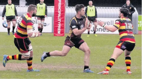  ??  ?? RGC centre Tiaan Loots (black) makes a strong run through the Carmarthen cover at Parc Eirias last Saturday. Picture: STEVE LEWIS