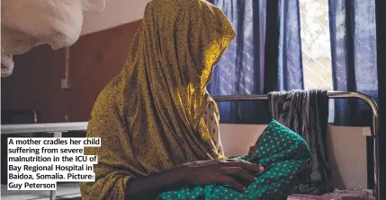  ?? ?? A mother cradles her child suffering from severe malnutriti­on in the ICU of Bay Regional Hospital in Baidoa, Somalia. Picture: Guy Peterson