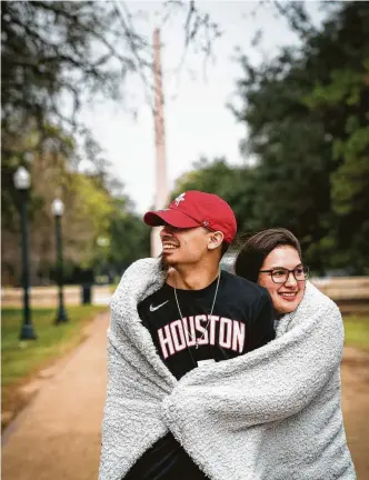  ?? Mark Mulligan / Staff photograph­er ?? Jerrica Soto holds her boyfriend, Erric Cabrera, as they stroll through Hermann Park wrapped in a blanket on Thursday. The pair said it wasn’t that cold when they left the house.