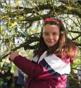  ?? Photo: Sheila Fitzgerald ?? Niamh Dineen tying a piece of cloth on the hawthorn tree beside the Holy Well of Inghne Buide in Dromtariff­e during the Pattern Day Mass in 2014. Legend has it that following this tradition will keep illness at bay for the entire year.