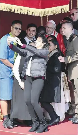  ?? AFP Photo / Tiziana Fabi ?? El Papa Francisco posa para un selfi con jóvenes el Domingo de Ramos