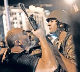  ??  ?? The struggle for Turkey: A Turkish policeman grabs the gun of a soldier he’s trying to arrest in Istanbul in the wake of the failed military coup.