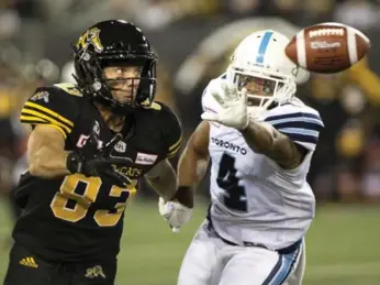  ?? PETER POWER/THE CANADIAN PRESS ?? Hamilton’s Andy Fantuz makes a one-handed catch while defended by Toronto’s Brandon Harris on Saturday.