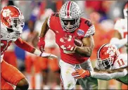  ?? CHRISTIAN PETERSEN / GETTY IMAGES ?? Ohio State’s J.K. Dobbins carries the ball through a tackle bid by Clemson’s Isaiah Simmons on Saturday in Glendale, Ariz. Dobbins had 141 yards in the first quarter but added just 33 more to his total.