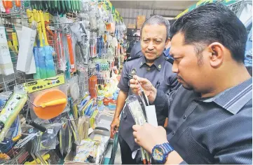  ??  ?? Ahmad Sabri (left) and Mohd Al Hafiz inspecting a paint brush during an operation. — Bernama photo