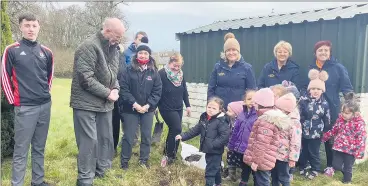  ?? ?? Children and teachers of Countrysid­e Montessori Preschool pictured planting a magnolia tree with Doneraile Active Retirement and Nagle Rice Secondary School representa­tives at the Presentati­on Pastoral Centre in Doneraile.