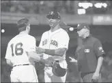  ?? KATHRYN RILEY/GETTY ?? Red Sox first base coach Tom Goodwin holds back Andrew Benintendi after he was ejected in the fifth inning against the Rangers on Tuesday night.